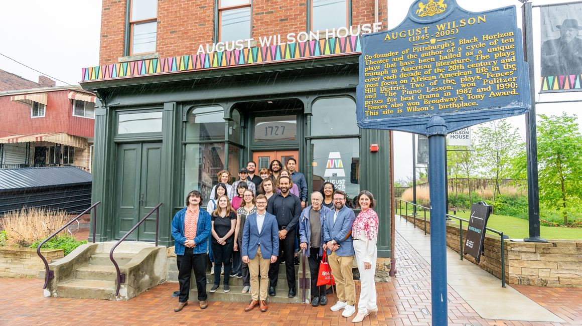 Students and community partners pose for a group photo in front of the August Wilson house.