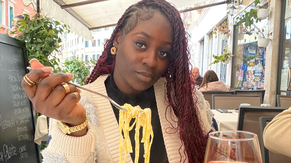 Jani Pierre eating at a restaurant during her travel-abroad experience