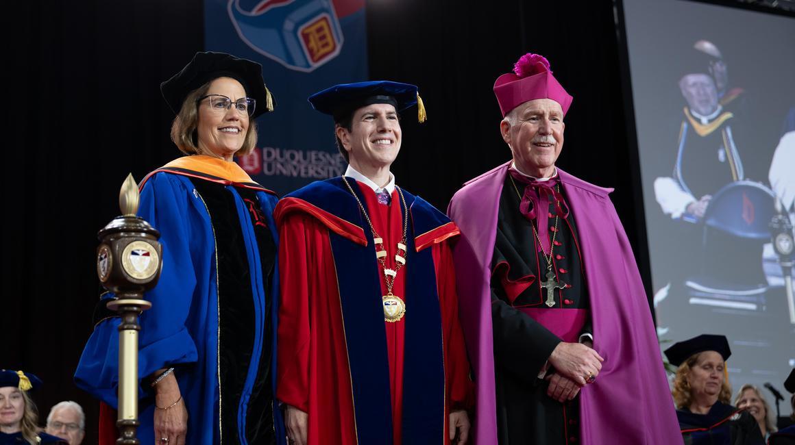 Dr. Dausey standing with Diane Hupp and the bishop.