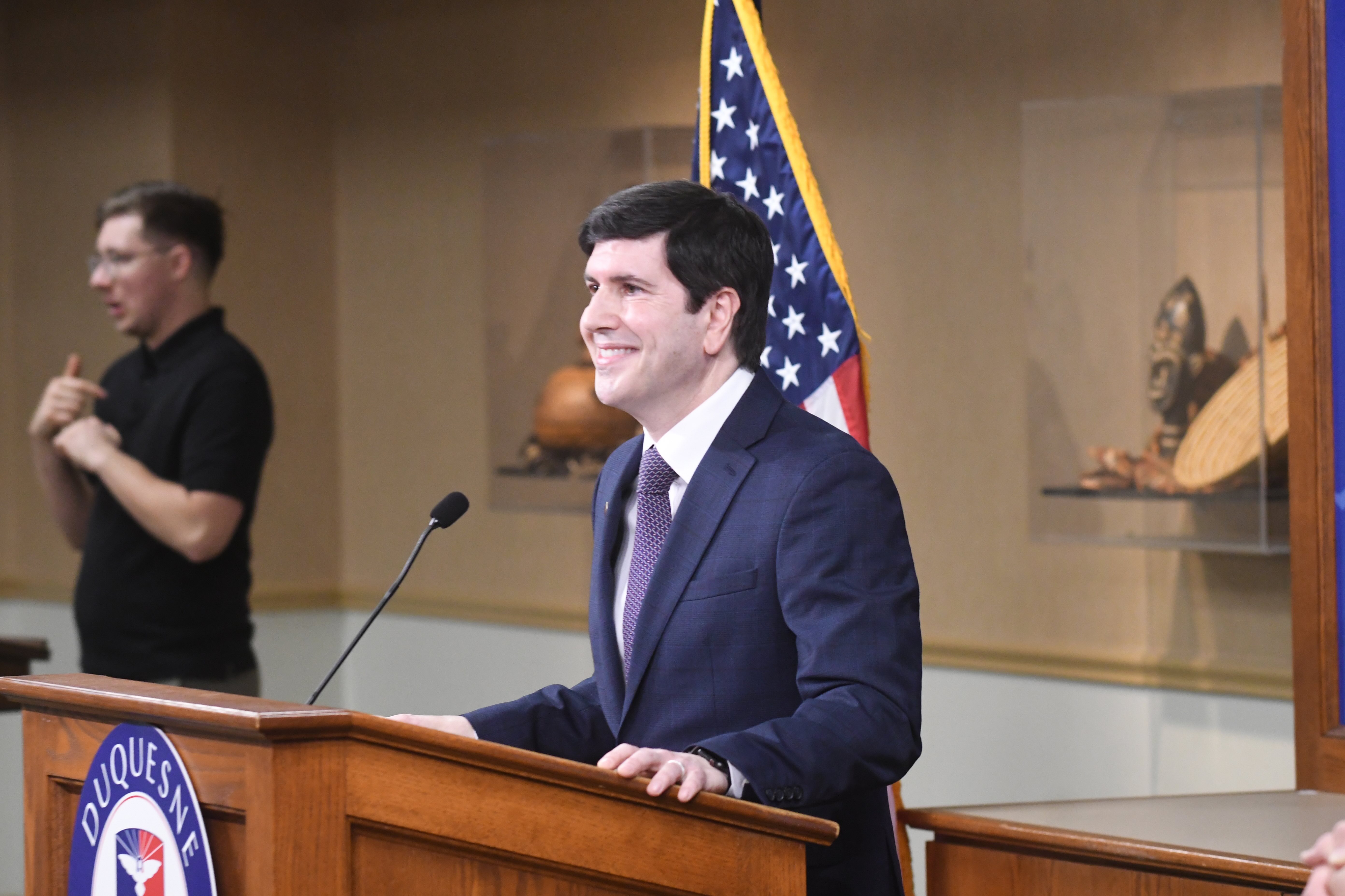 David Dausey wearing a suit and standing at a podium