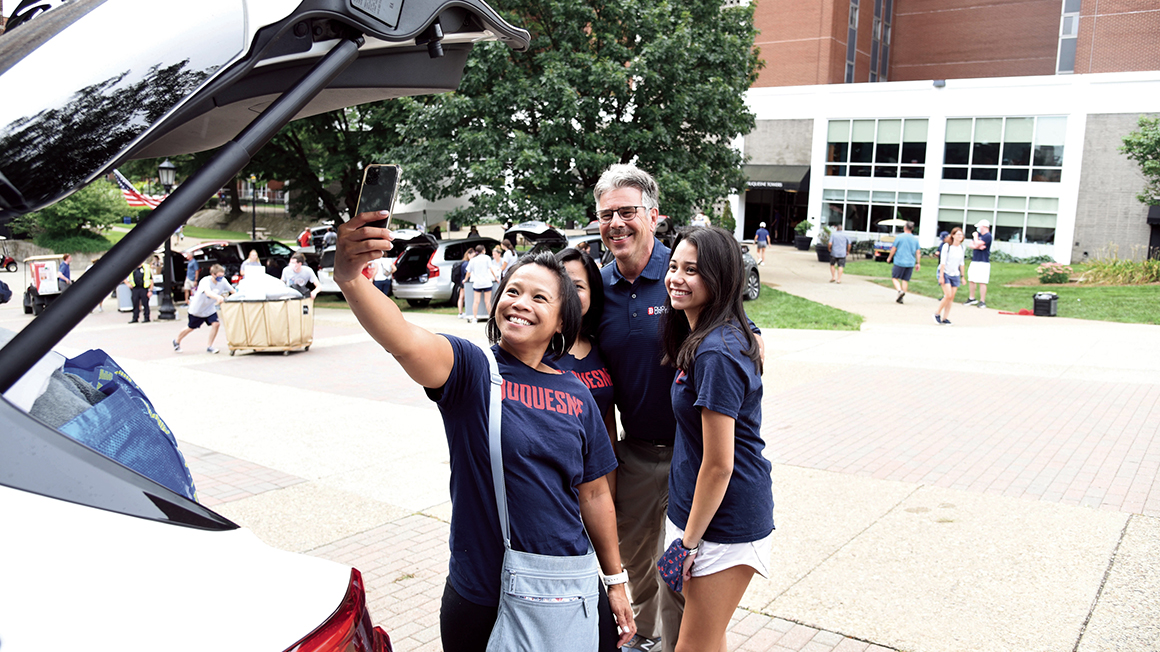 President Gormley taking selfie with students on campus.