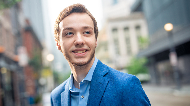 Male student with downtown blurred in background