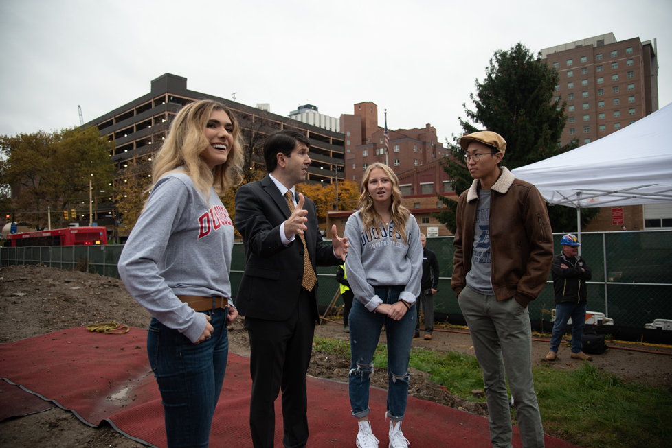 Dr. Dausey with three students at COM groundbreaking