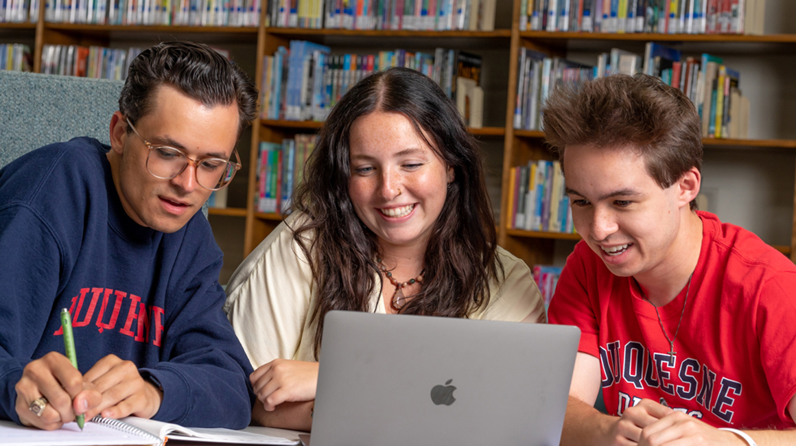 Students around laptop at Duquesne