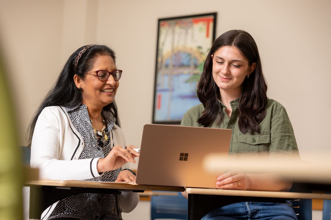 Advisor with student looking at laptop