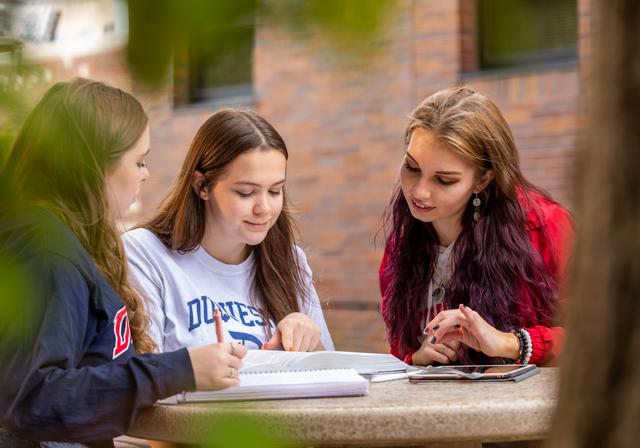 Duquesne students gathered around assignment outside on campus.