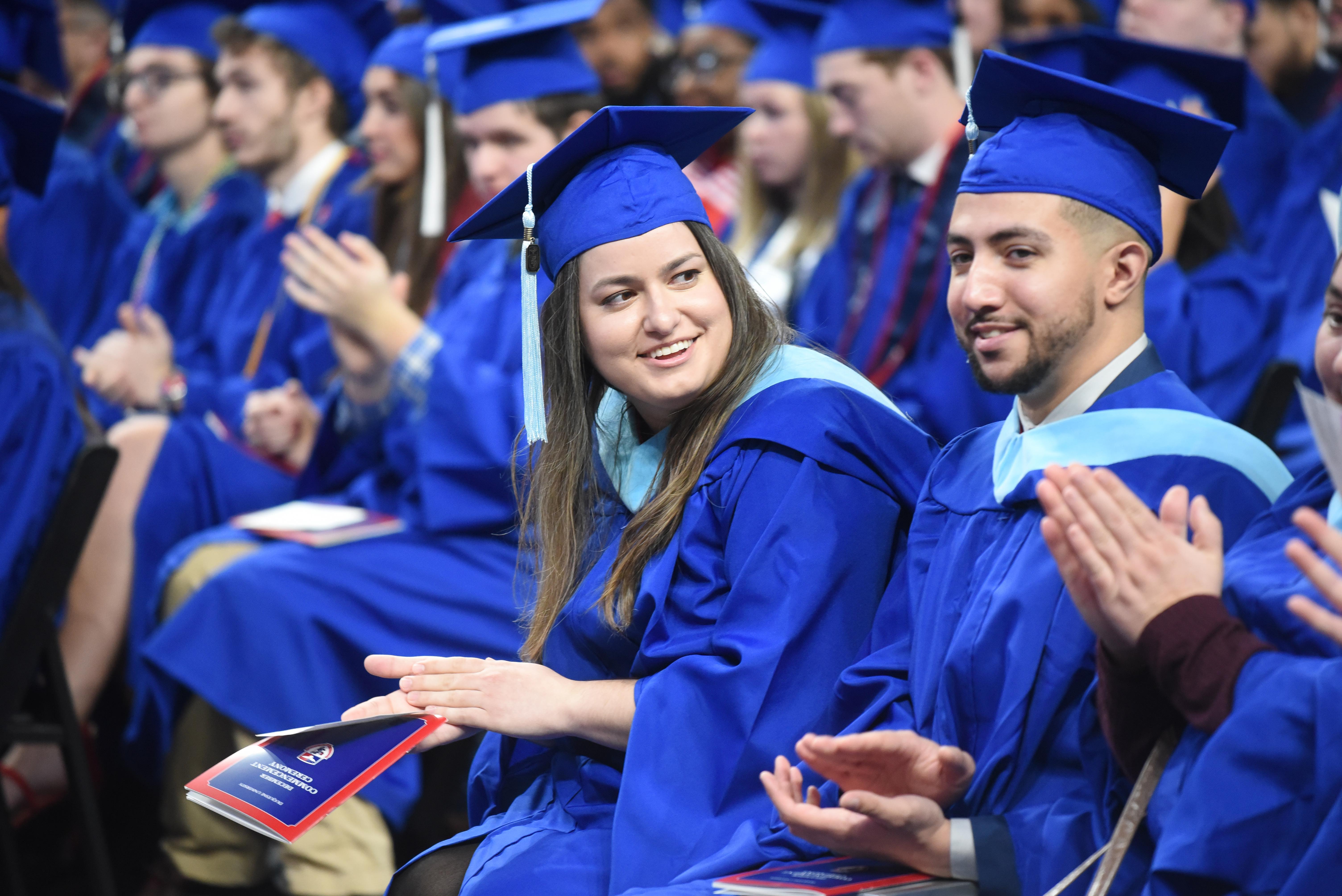 two students in regalia at commencement