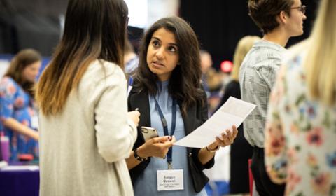 Female employer and female student talking at a Career Fair.