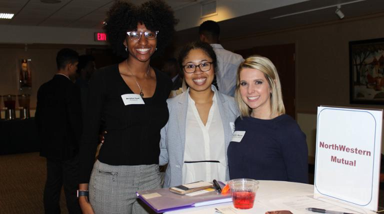 Students and employers pose at networking event.