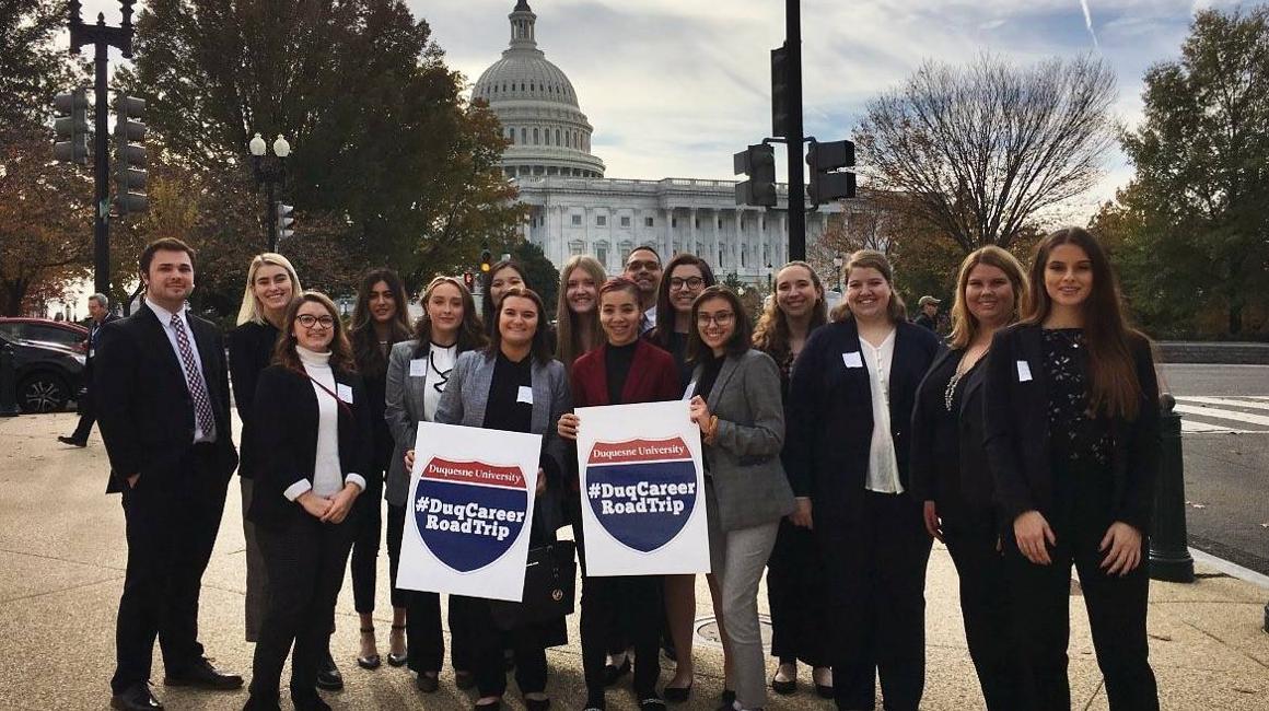 Alumni and students posing on the streets of Washington D.C., during a Career Road Trip