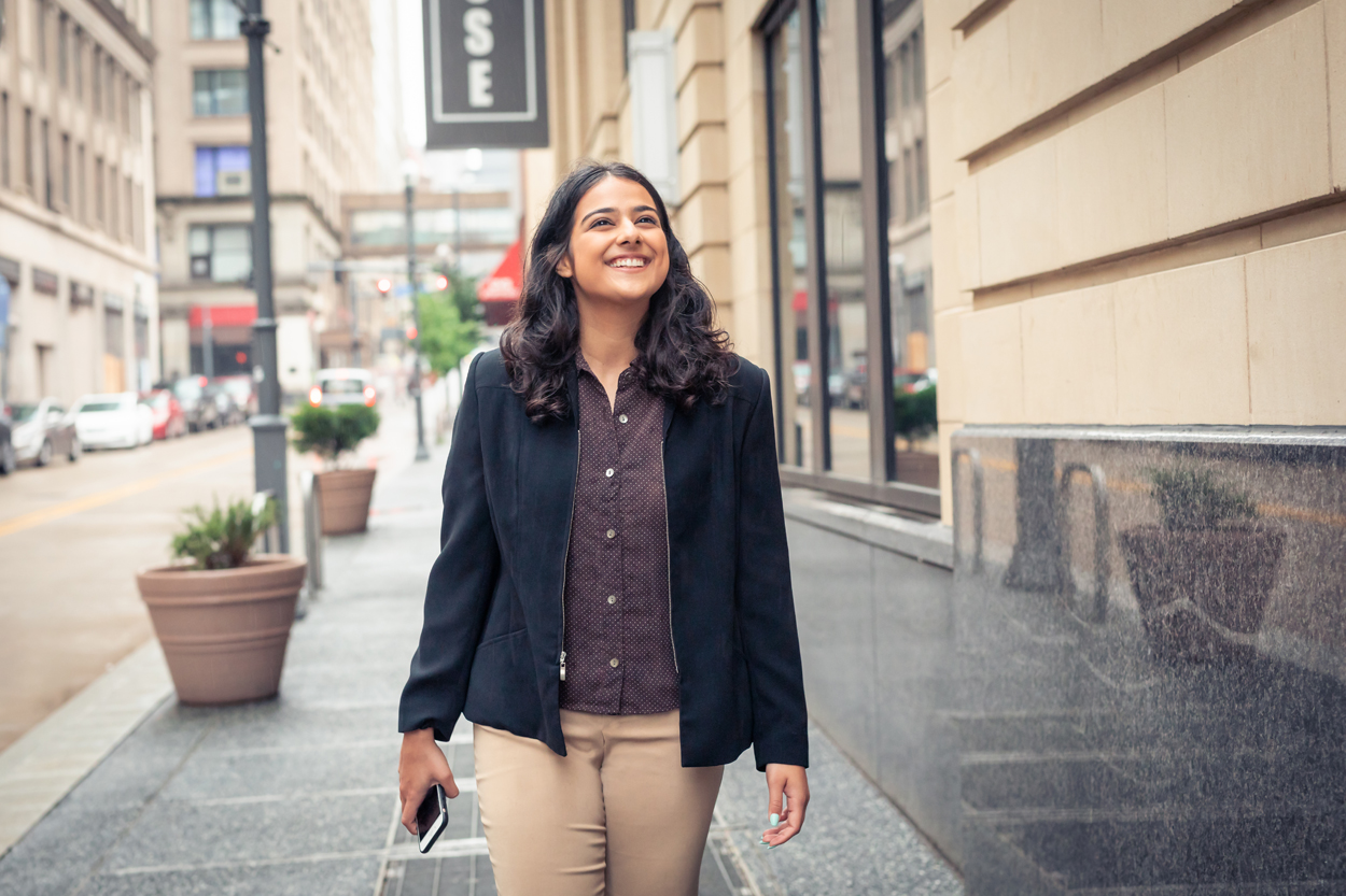 Female student walking through streets of Pittsburgh.