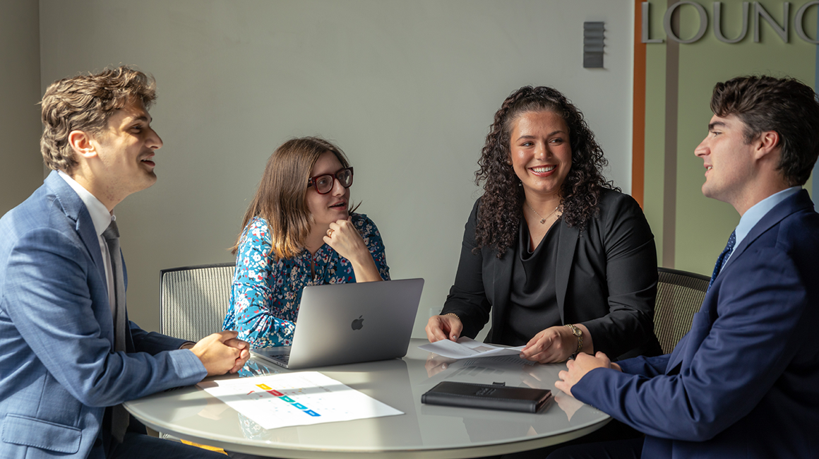 Four School of Business students working together.