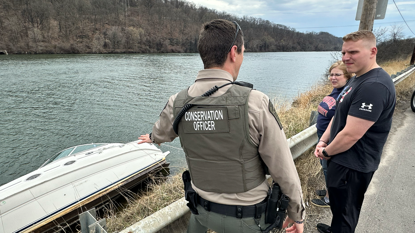 Conservation Officer explains the hazards to students Maureen McGaffin and Yann Evain.