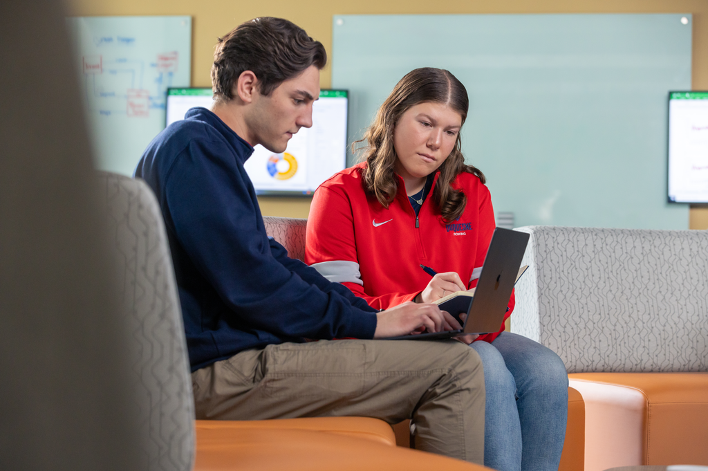 Two students focus intensely while studying.