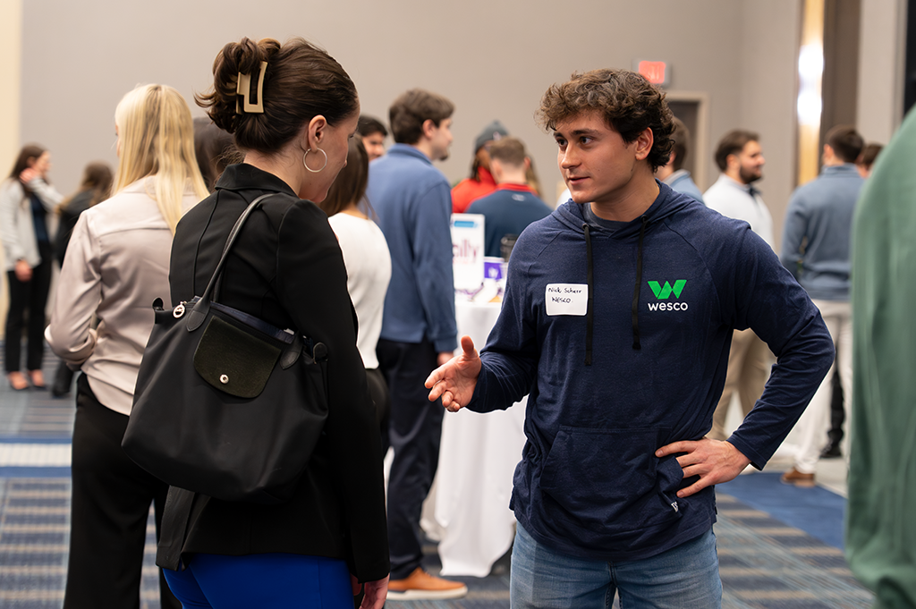 A student talks with a professional at a networking event.