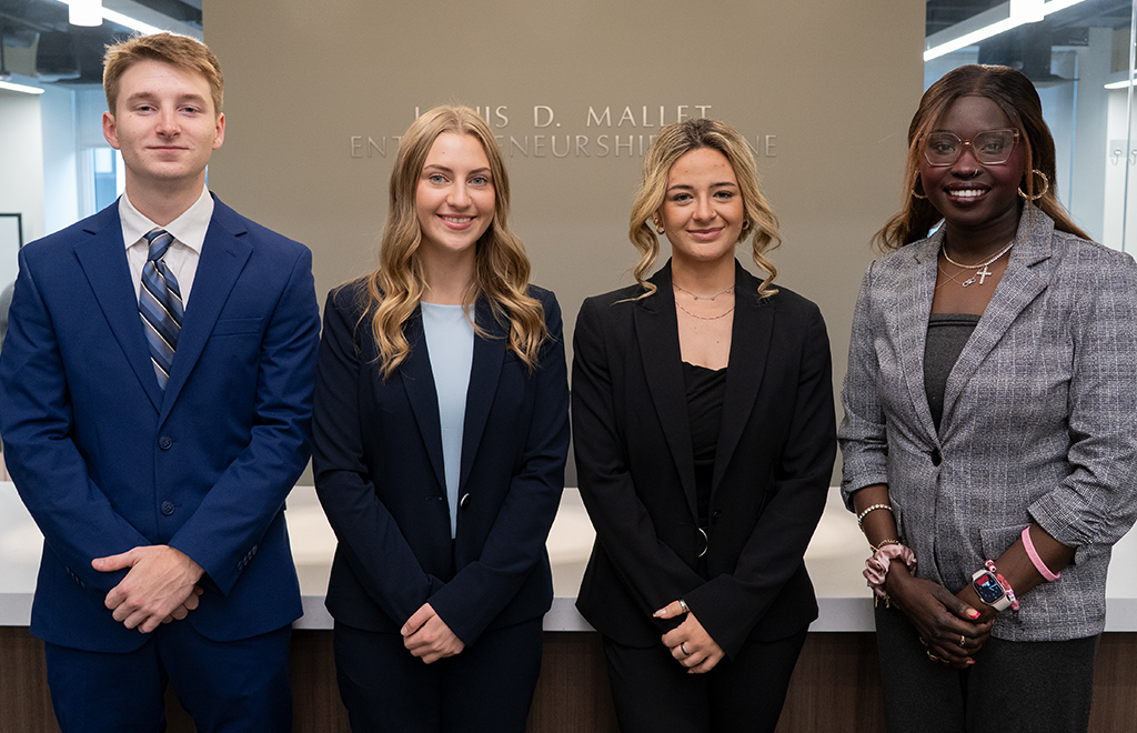 Sales students in professional attire pose for a picture.