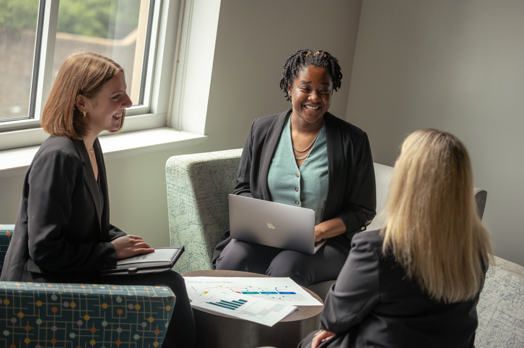 Graduate students smile and laugh together.