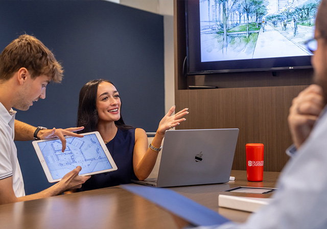 Undergraduate and graduate students presenting a project to a corporate partner.