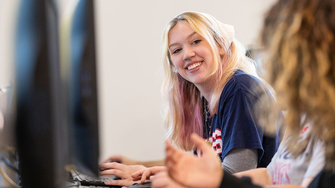 A bsuiness student smiles at a classmate.