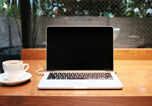 Photo of a laptop and cup of coffee.