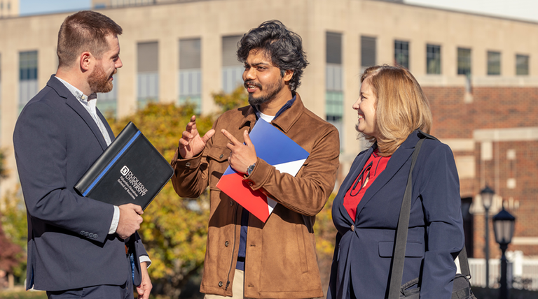 Graduate students talk outside on Duquesne University's campus. 