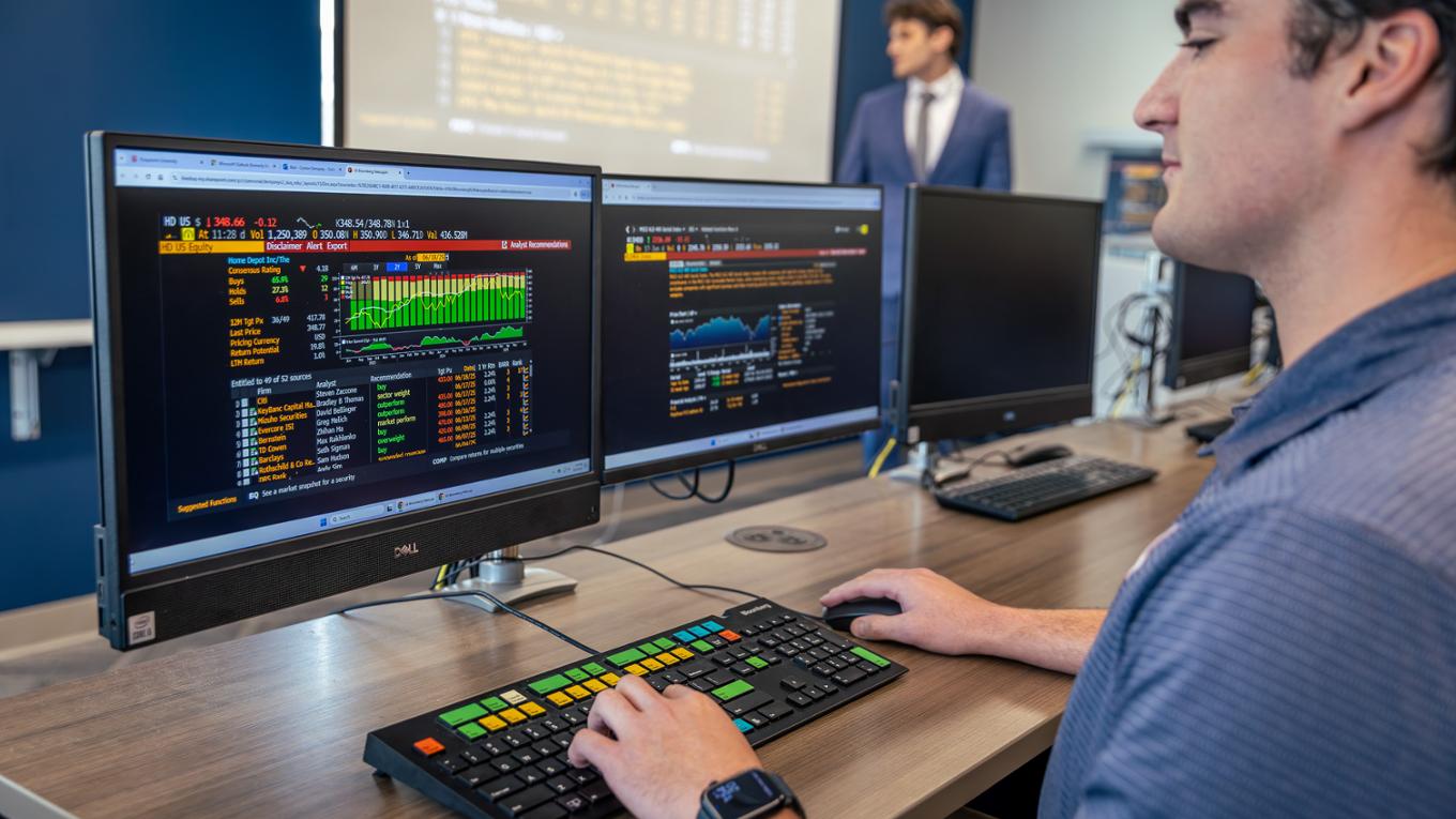 A student works on a Bloomberg terminal in a finance lab.