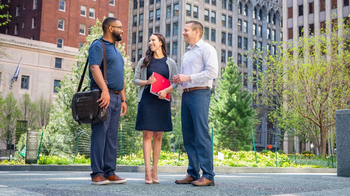 Three business students talk in downtown Pittsburgh. 