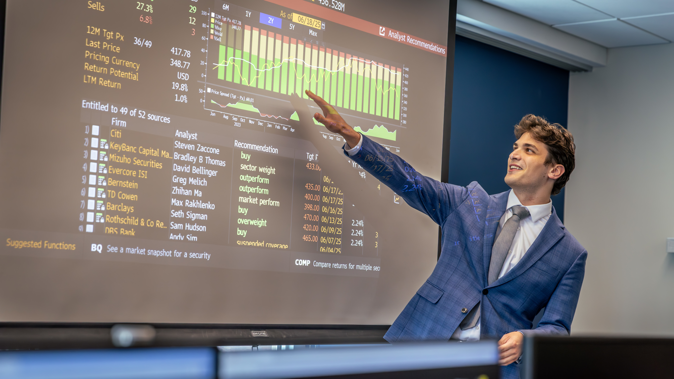A business professionals points at a chart in the Investment Strategy Institute. 