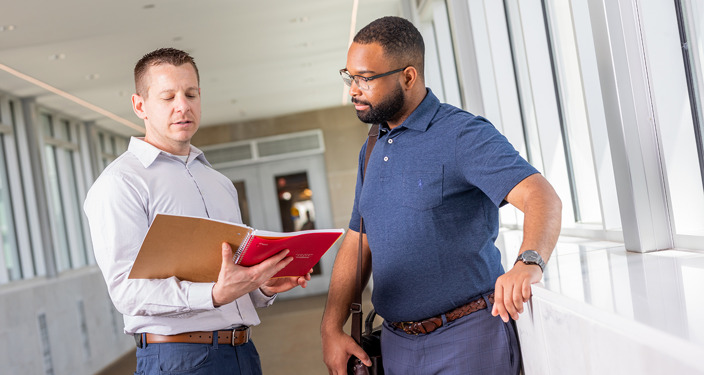 Two business students talk on the skywalk. 