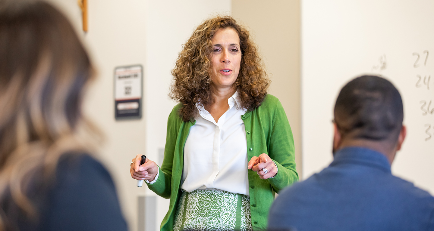 An instructor talks to students in a classroom. 