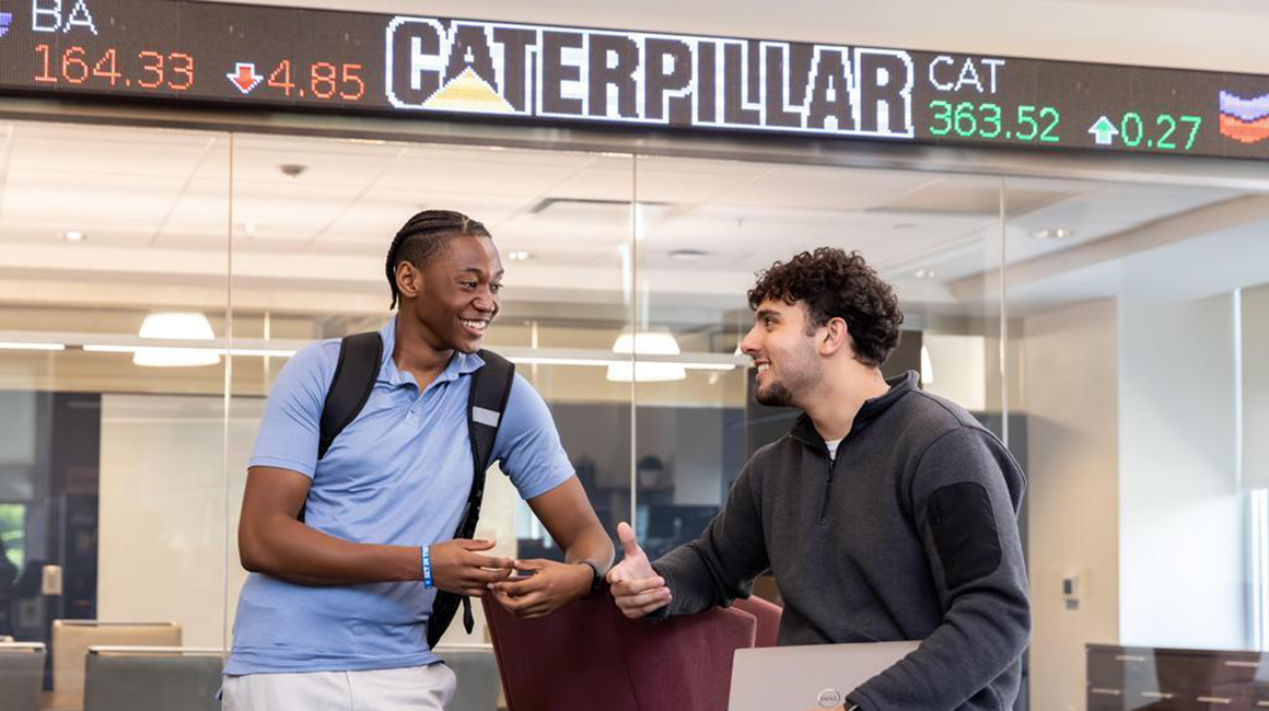 Business students in front of the stock ticker.