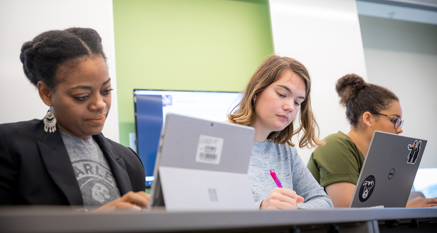 Business students work on laptops in class.