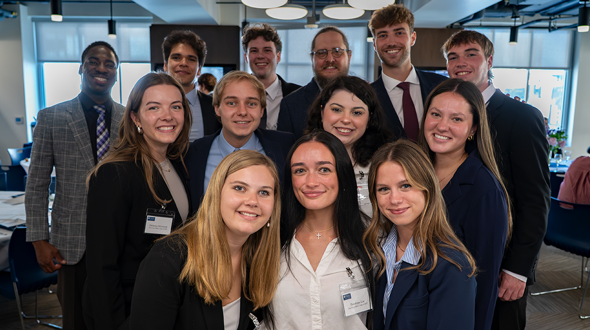 The 2026-2027 One-Year MBA cohort standing together in Rockwell Hall for a group photo.