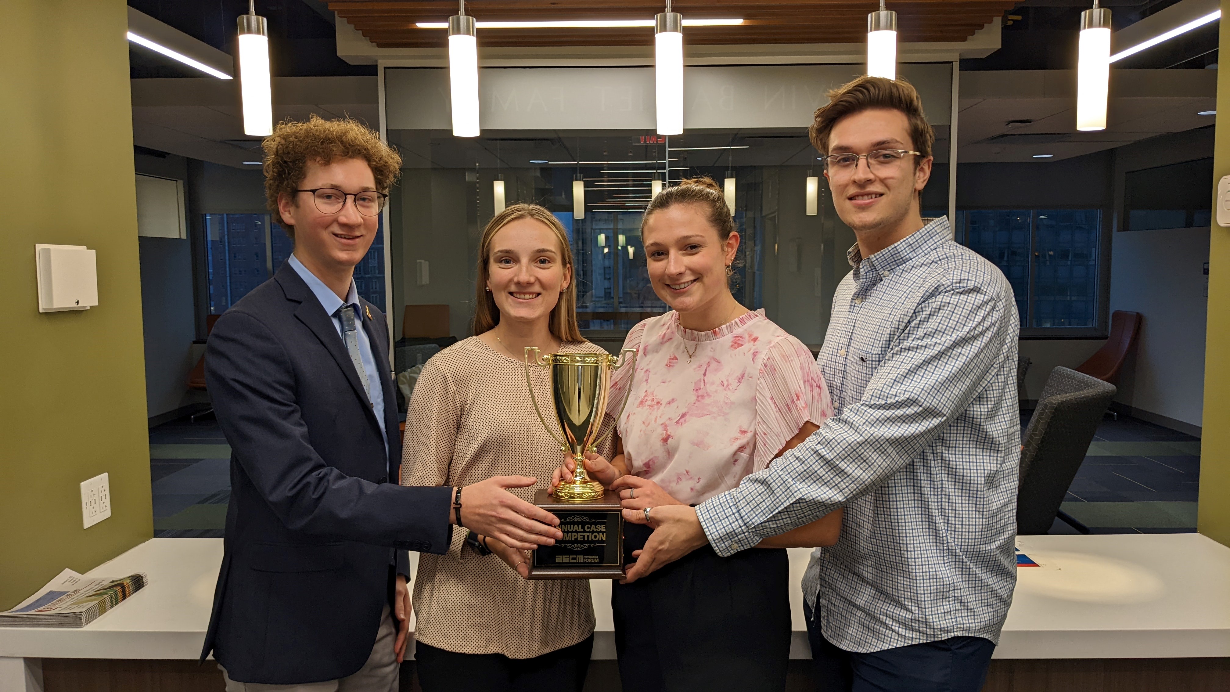 The 2022 SCM case competition winning team poses with their trophy. 