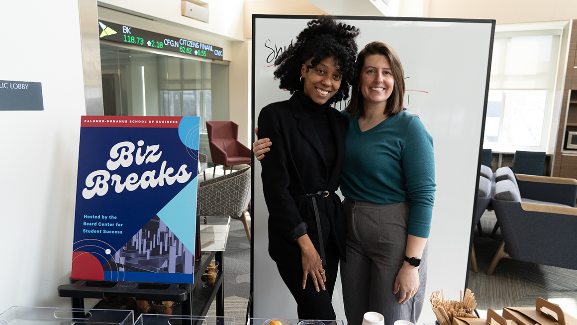 Two student success coaches standing together at a Biz Break in Rockwell Hall.