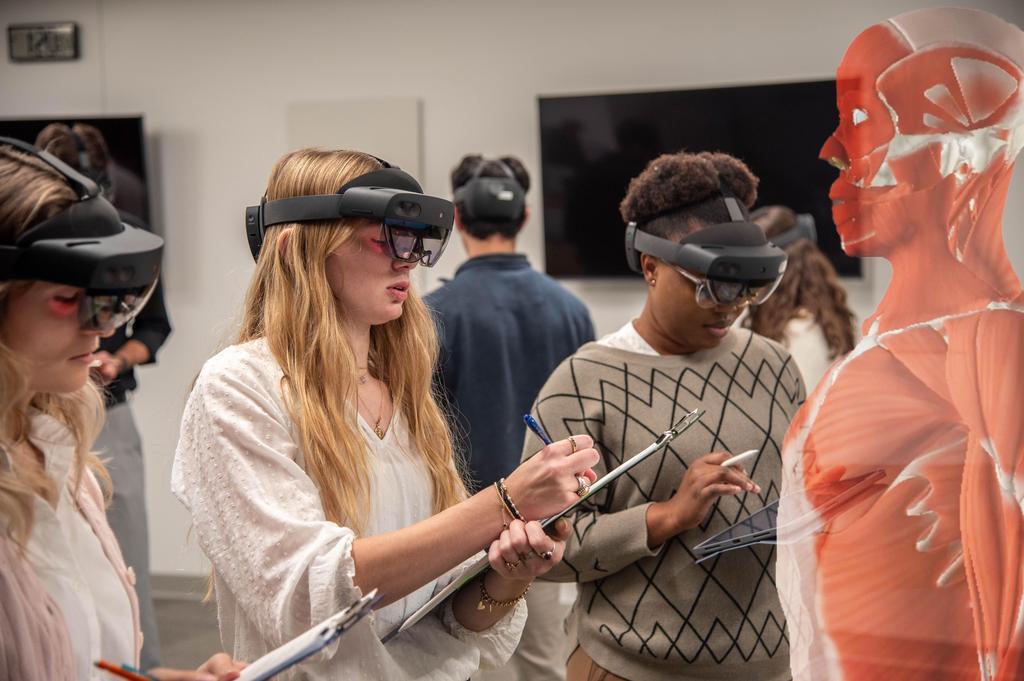 DUQCOM MBS students work alongside faculty exploring the holoanatomy augmented reality tech for anatomy class.