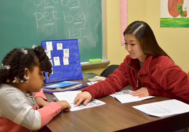 Reading Clinic student and Duquesne graduate student pointing at book together