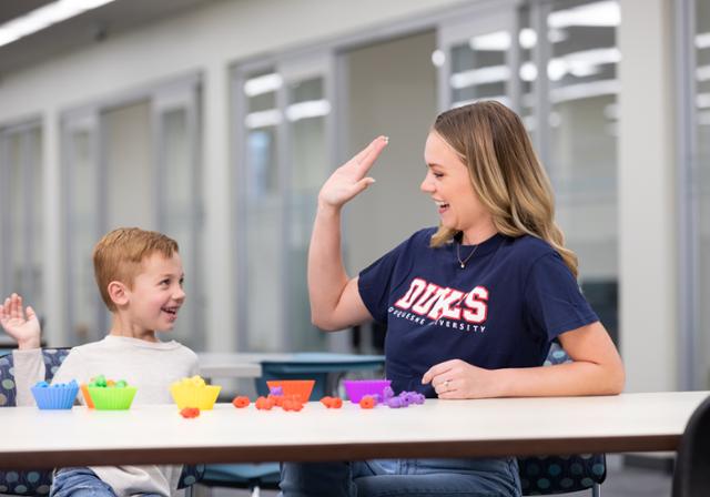 A woman and child celebrate with a high five.