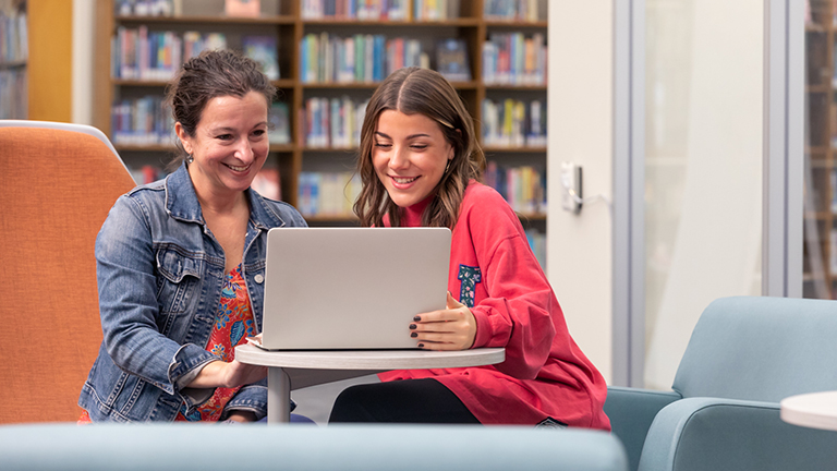 Duquesne students working in library with faculty member