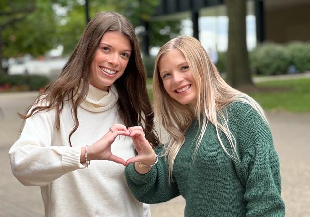 Two students on campus joined my marking part of a heart with hands coming together
