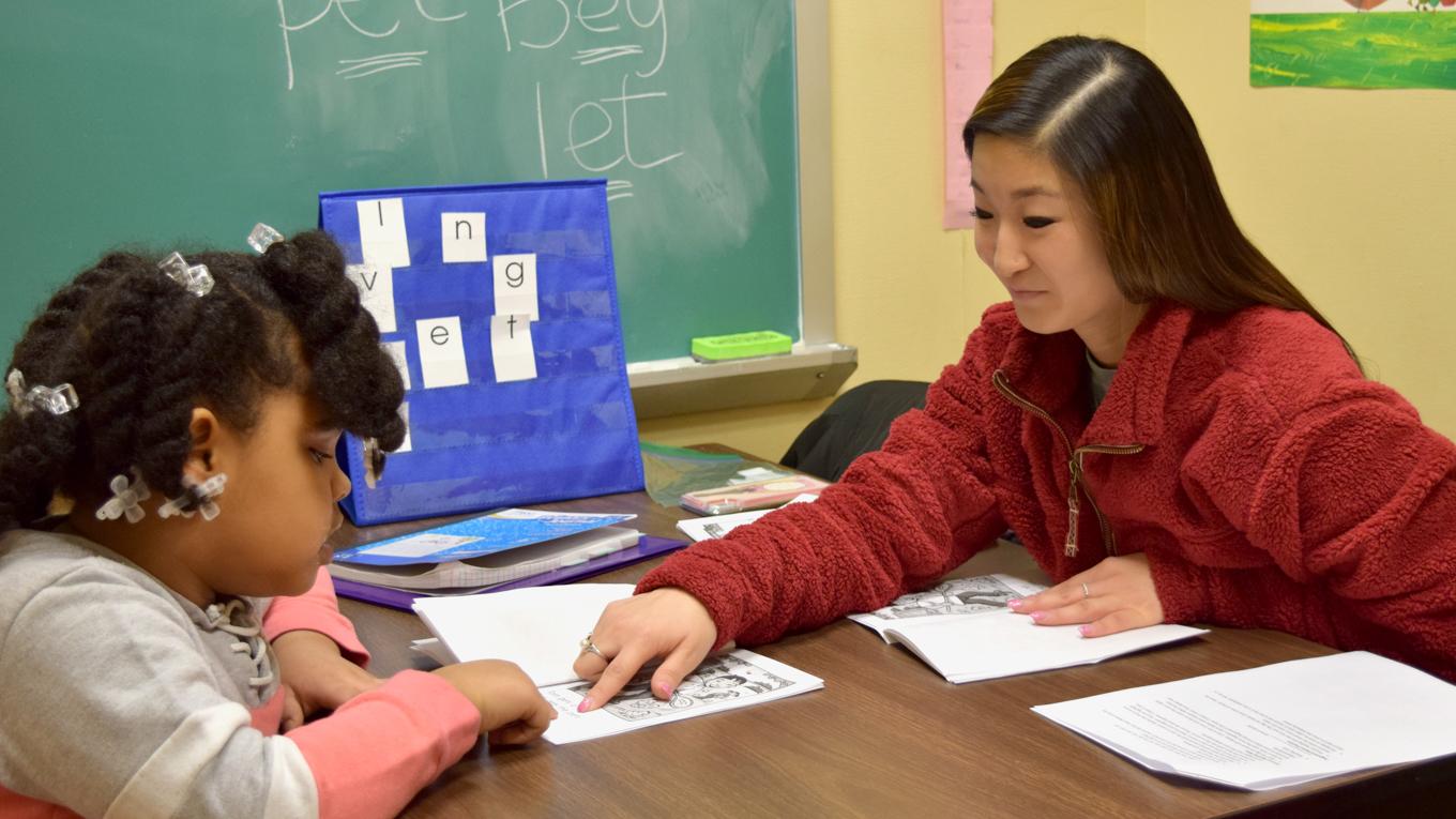 Image of young learner engaging in reading instruction with Duquesne student in reading clinic