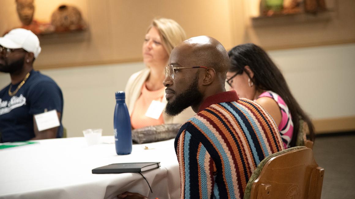 Doctoral students sitting around table listening to lecture