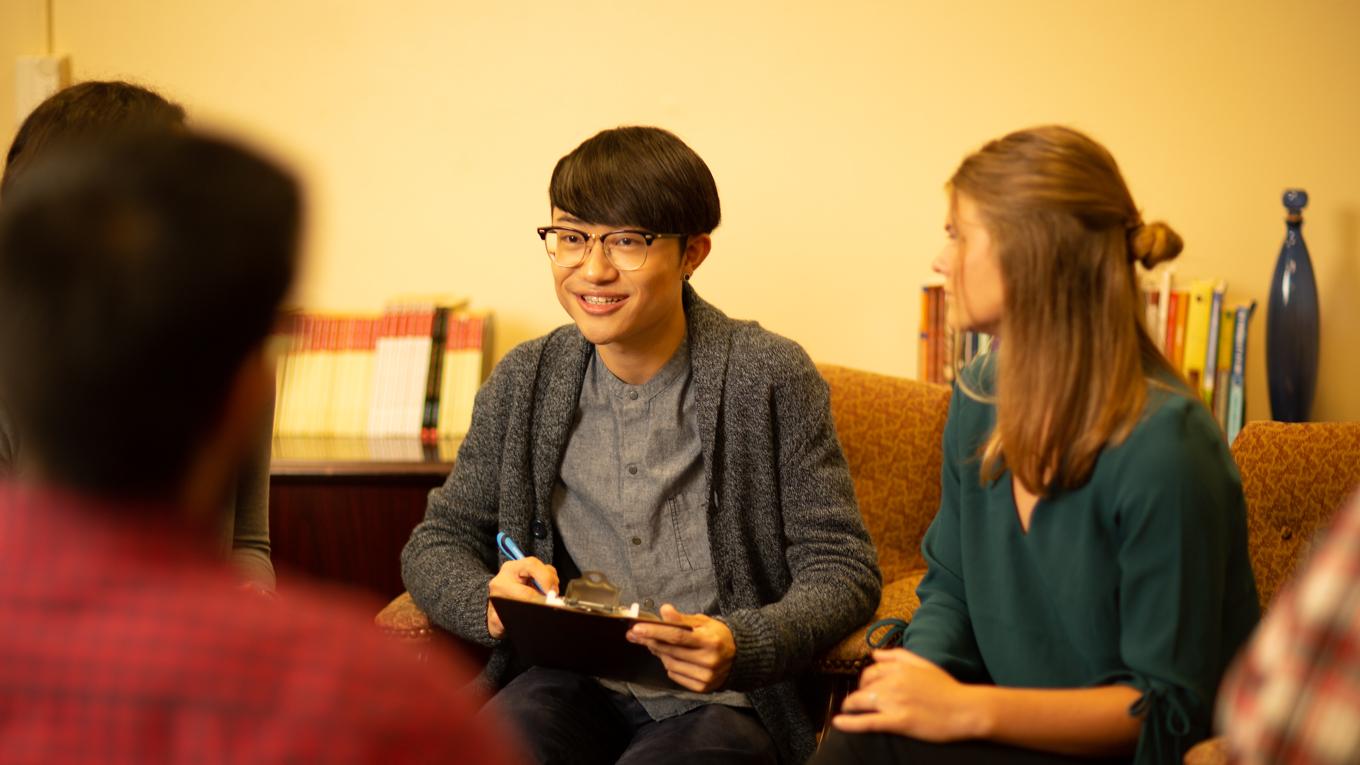 Counselor talking to group of clients seated in circle in room