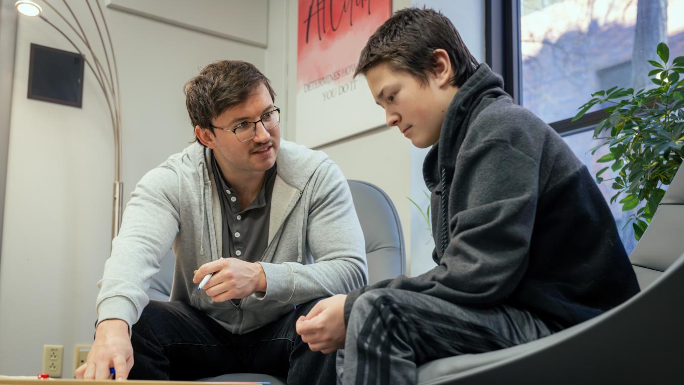 MAT Secondary Education graduate teaching high school student seated in classroom in Pittsburgh Pennsylvania.