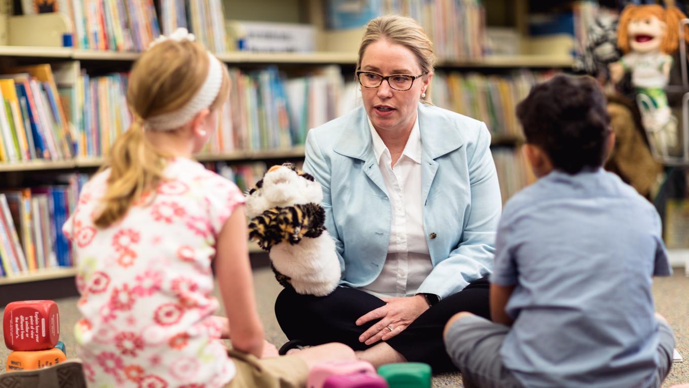 LPC School Counselor engaging with two young learners with a puppet in school setting