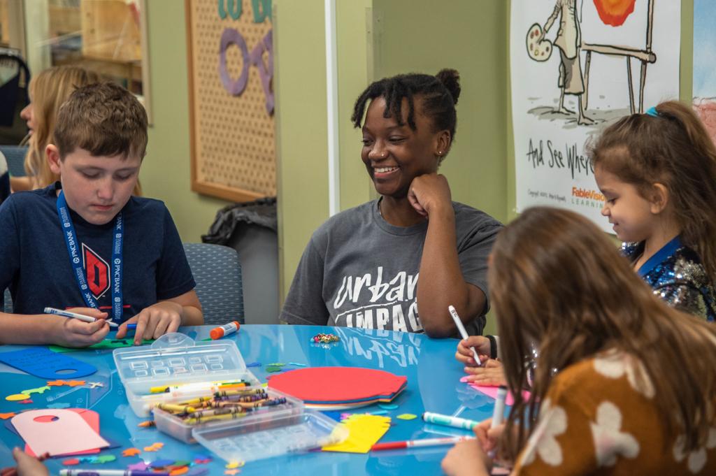 Duquesne student teacher with students in library curriculum center reading lessons