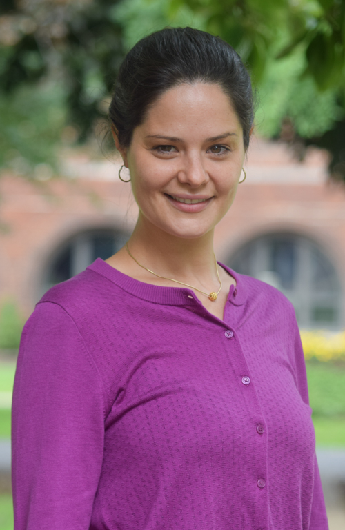 Dr. Green's headshot with campus trees and building in background