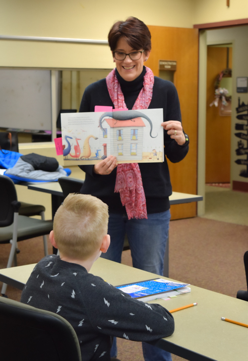 Dr. Meyer engaing in reading lesson with elementary school student.