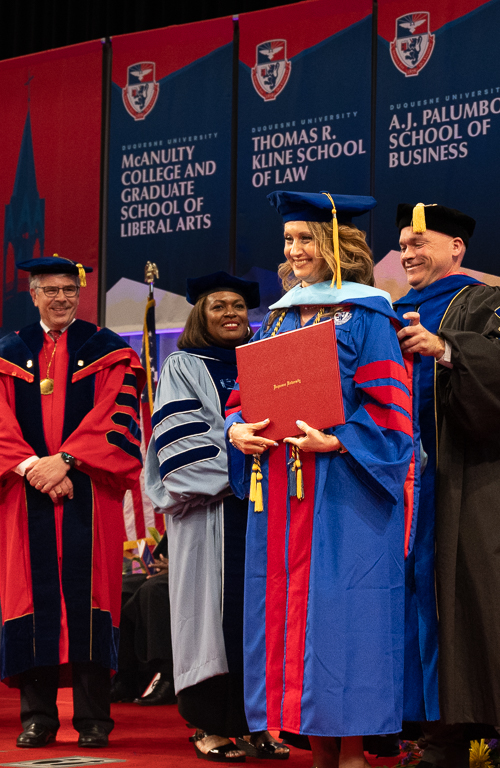 Dr. Odeese M. Ghassa-Khalil being hooded for her doctorate degree on the School of Education Commencement stage by faculty and President Gormley