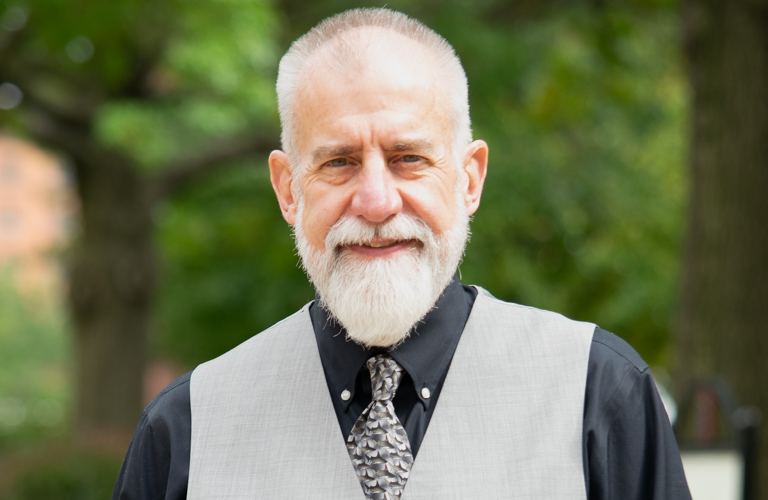 Headshot of Dr. McCown on campus with trees in background